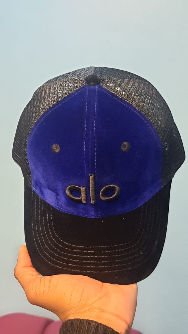 Alo Velvet Trucker Hat in a blue/black colorway.